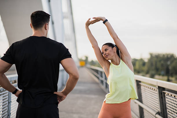 istock Beautiful woman warming up while instructior supervises 2227418795