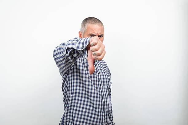 istock Serious man showing thumbs down gesture expressing dislike 2227425383