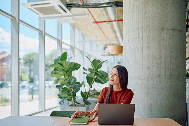 istock Businesswoman working on laptop and taking notes in modern office 2227426160