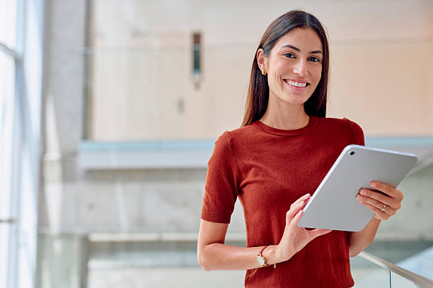 istock Young businesswoman smiling and using digital tablet in modern office building 2227426696