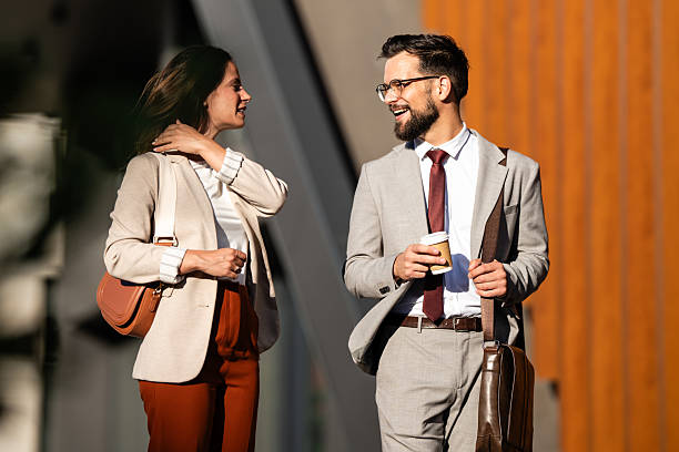 Business people walking and talking outdoors during coffee break