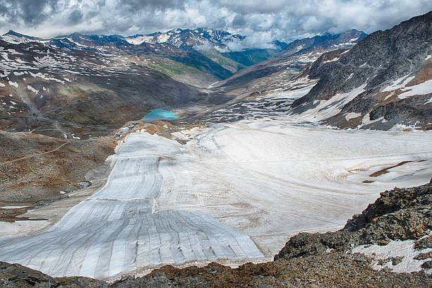 Scenic panorama showing the melting Schnalstal Glacier in South Tyrol, Italy. Covered with white sheets to reduce ice melting, a consequence of global warming