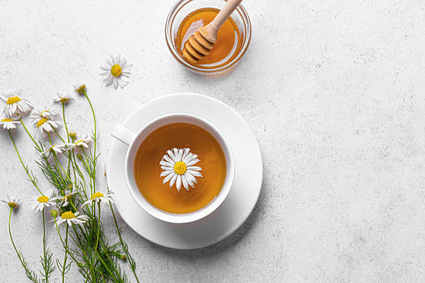 Chamomile tea cup with honey and chamomile flowers