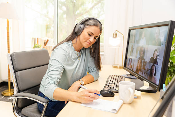 istock Middle-aged Woman in Video Conference, Taking Notes 2227430460