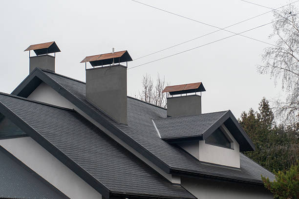 istock A residential building showcases modern architectural design with distinctive chimneys topped with metallic roofs against a cloudy sky 2227431361