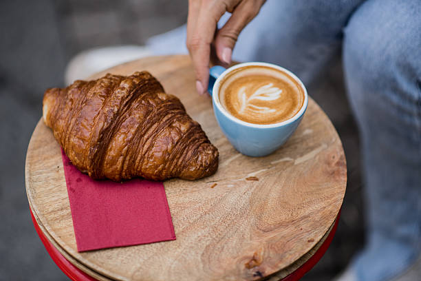 istock Croissant and cappuccino on table outdoors 2227433101