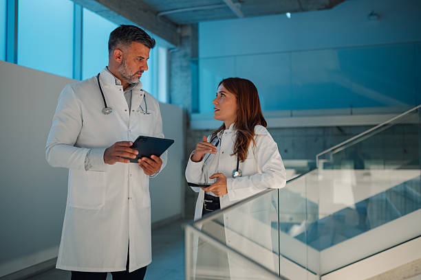 istock Doctors discussing patient data using digital tablet in hospital corridor 2227433809