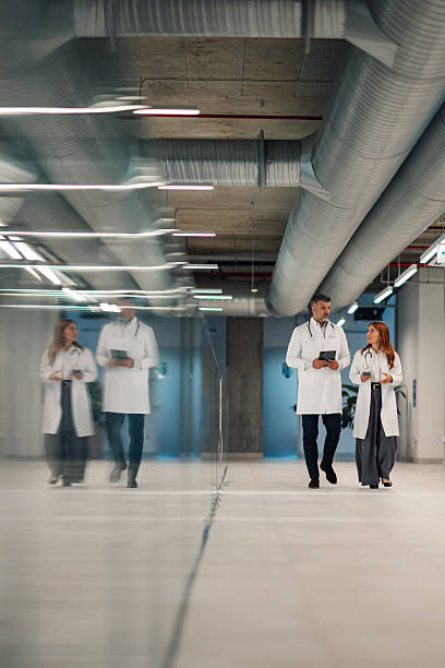 istock Doctors walking and talking in a modern hospital corridor 2227433880