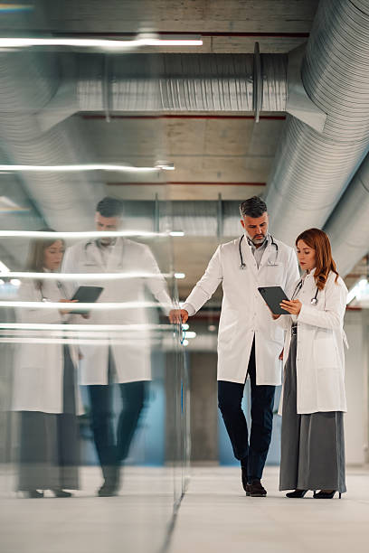 istock Doctors using tablet and discussing diagnosis in hospital corridor 2227433892