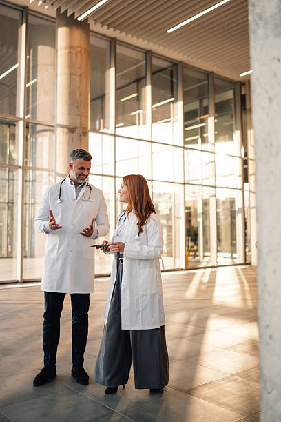 istock Doctors wearing lab coats discussing in hospital hallway 2227433913