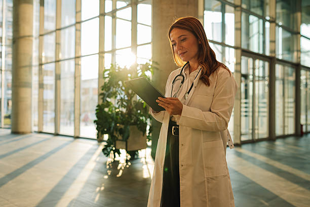 istock Female doctor using digital tablet in modern hospital lobby 2227433919
