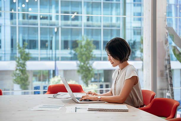 istock Middle-aged woman using computer technology for financial marketing work online. Busy mature Asian professional businesswoman analyst working concentrated on laptop pc at desk in office. Copy space 2227434516