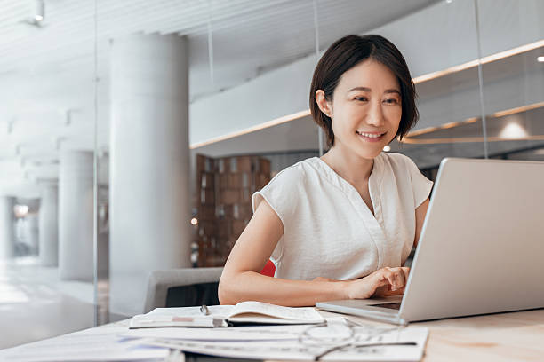istock Middle-aged woman using computer technology for financial marketing work online. Busy mature Asian professional businesswoman analyst working concentrated on laptop pc at desk in office. Copy space 2227434522