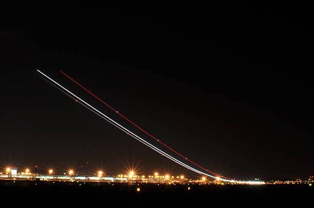 istock Airplane Taking Off at Night with Long Exposure Creating a Long Light Trail 2227440967