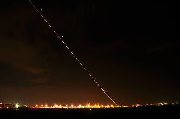 istock Airplane Taking Off at Night with Long Exposure Creating a Long Light Trail 2227440981
