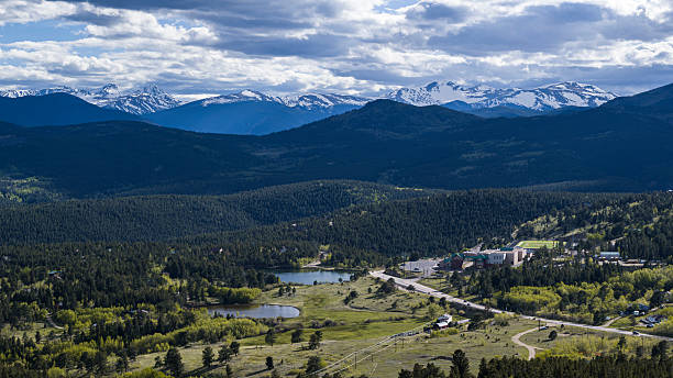 istock Continental Divide overlook reveals expansive valley with scattered buildings and infrastructure in Gilpin County, Colorado. Snow-capped peaks frame the distant horizon. 2227443293