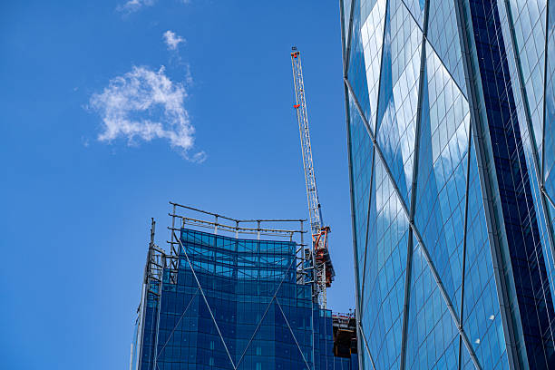 Moscow, Russia - May 25, 2021: A firefighting helicopter equipped with a suspended water bucket flies between towering buildings, combatting flames in the heart of the city.