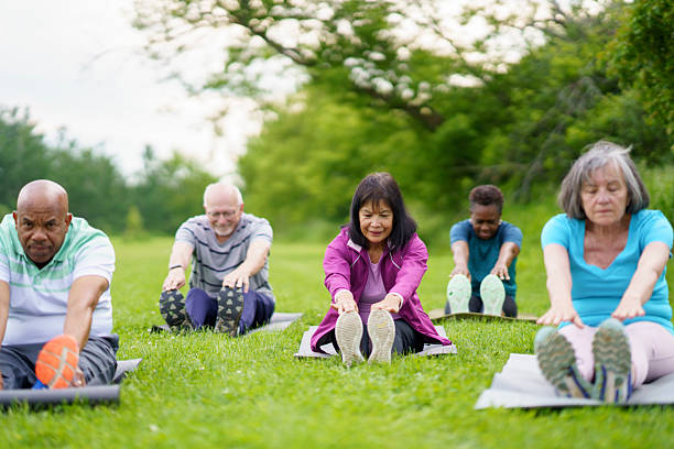 istock Group of Diverse Individuals Exercising Outdoors in a Green Park Setting 2227444801