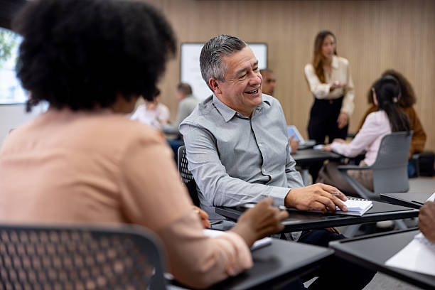 istock Happy senior man back in school and talking to his classmates 2227445767