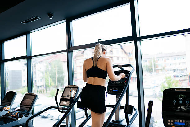 istock Young woman doing cardio exercise on stair climber machine in gym 2227455238