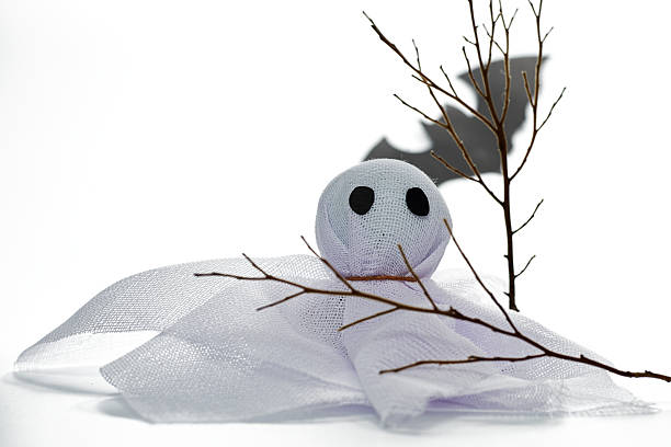 istock Creative Ghost Decoration Made of White Fabric With Twigs on a Plain Background for Halloween Celebration Ideas 2227459775