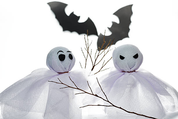 Two cute handmade ghost dolls with bats, a creative Halloween decoration concept.