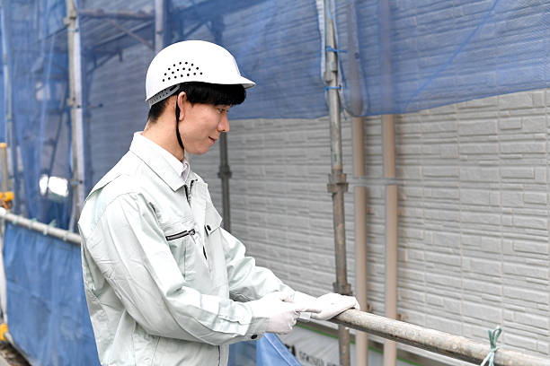 Male craftsman fixing building materials with a tacker.