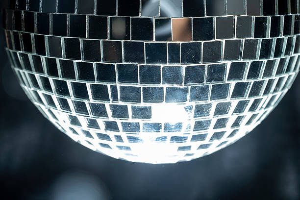 Disco ball hanging is comprised of small mirrors and has a light reflecting on it for a party effect