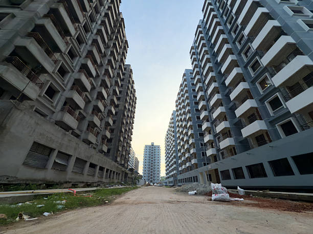 A wide-angle stock image showcasing a vast residential development featuring multiple modern apartment buildings in various construction phases. This photograph represents large-scale housing solutions, significant real estate investment, and the dynamic growth of an urban area.