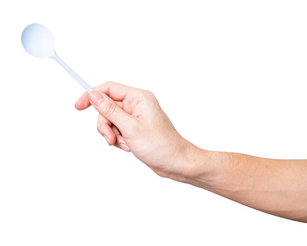 istock Male hand holding a white plastic spoon isolated on white background. 2227481390