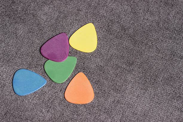 multi-colored guitar picks on a gray background. with space for the text. close-up. lifestyle. flat lay