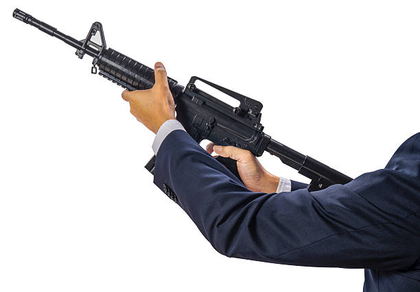 Young afro american man using umbrella like a gun and shooting isolated over gray background