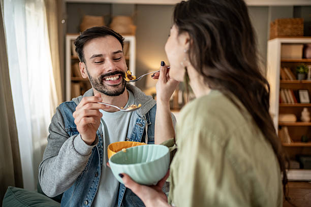 istock Happy couple feeding each other cereal at home 2227489805