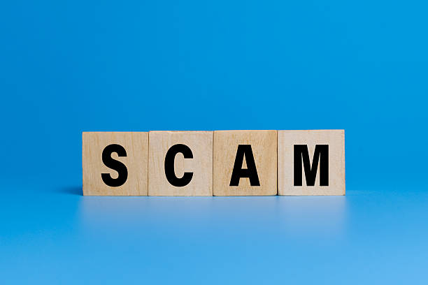istock scam word text on wooden blocks isolated on blue background 2227489872