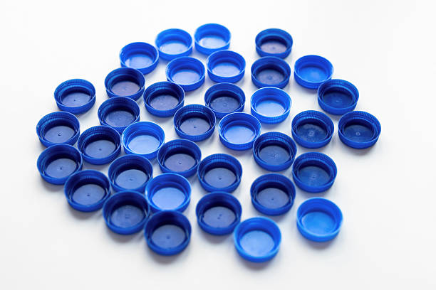 Top view on a pile of blue plastic bottle caps on white background