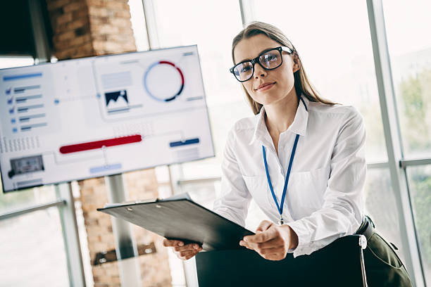 istock Confident Businesswoman With Clipboard in Office Setting Analyzing Data on Screen Demonstrating Leadership and Professionalism 2227495337