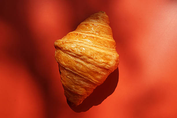 istock Close up plain butter croissant on red background 2227497833