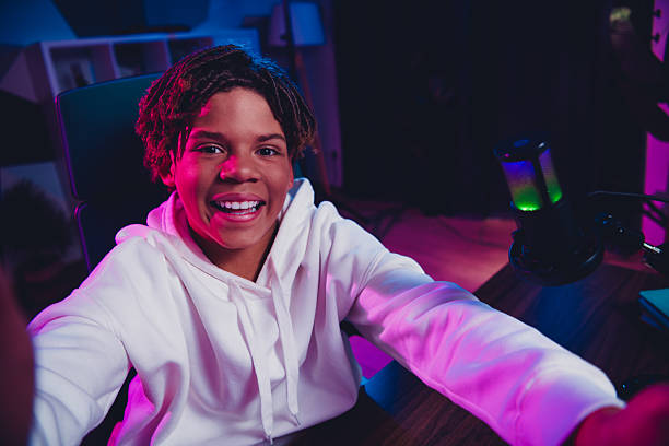 istock Cheerful Young Gamer and Content Creator Engaged in Streaming with Vibrant Neon Lights 2227498181