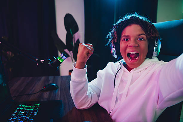 istock Excited young gamer celebrates victory while streaming in a vibrant neon-lit room using gaming equipment 2227498215