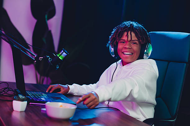 istock Young gamer and content creator streaming online from home with a joyful expression wearing headphones and white hoodie 2227498266