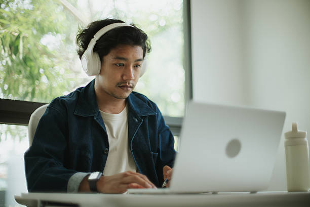 istock Asian man doing online learning at home. 2227500378