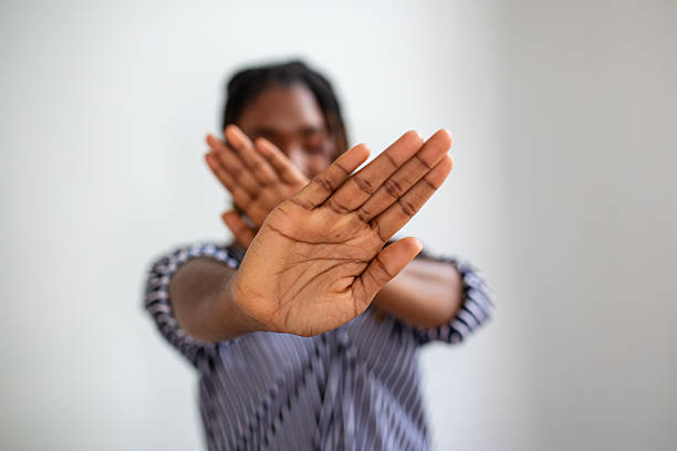 istock Woman defending herself from attack. Stop. Hands outstretched. campaign stop violence against women. African American woman raised her hand for dissuade with copy space 2227502205