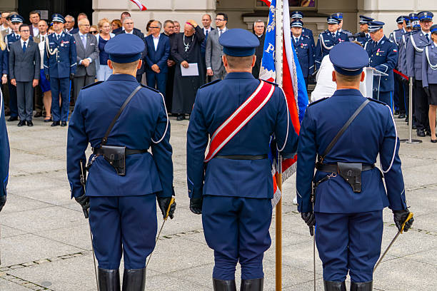 Kalisz, Greater Poland Voivodeship, Poland - july 22, 2025 Uniformed police officers with sabres and national flag participating in a Police Day ceremony with officials and attendees in the background