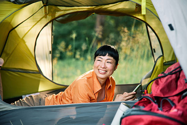 istock Smiling Japanese Woman Relaxing Inside Camping Tent 2227503665