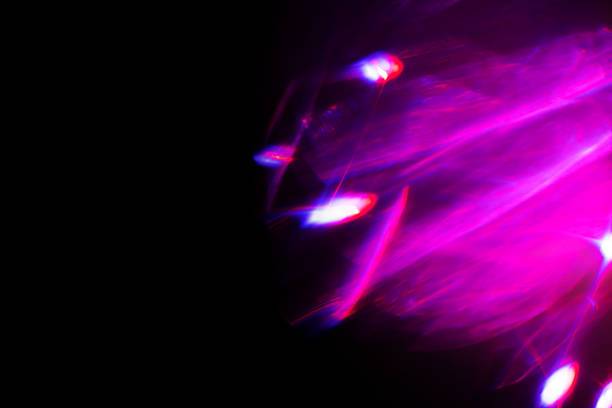 Blur neon light. Lens flare overlay. Bokeh fluorescent flash gleam. Defocused blue purple color flecks on dark black abstract background.