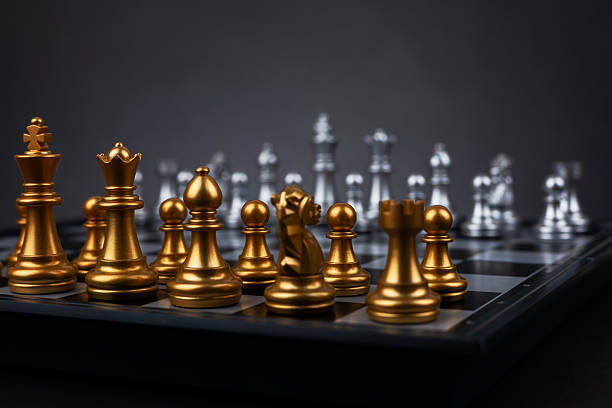 istock Gold and silver chess figures placed on wooden chessboard. Intellectual duel and tactical battle in business. 2227505316