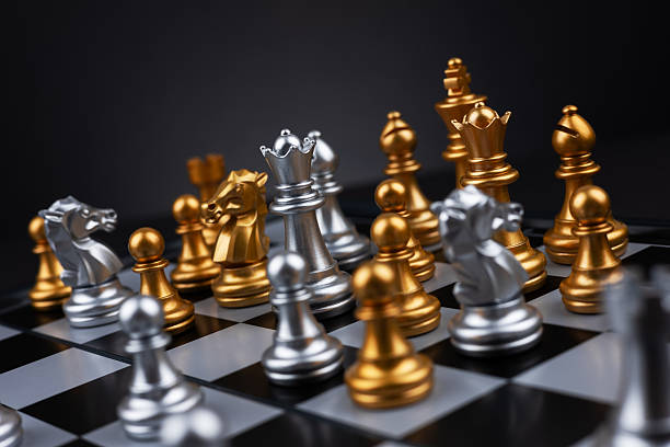 istock Gold and silver chess figures placed on wooden chessboard. Intellectual duel and tactical battle in business. 2227505320