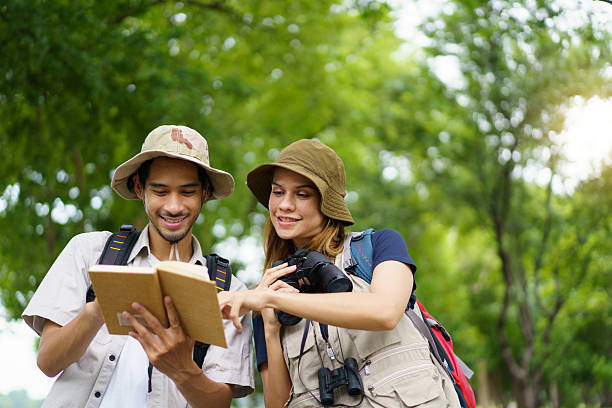 istock Man and woman joyfully birdwatching activity in a park. They study about bird watching. 2227505767