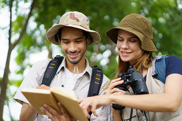 istock Man and woman joyfully birdwatching activity in a park. They study about bird watching. 2227505774