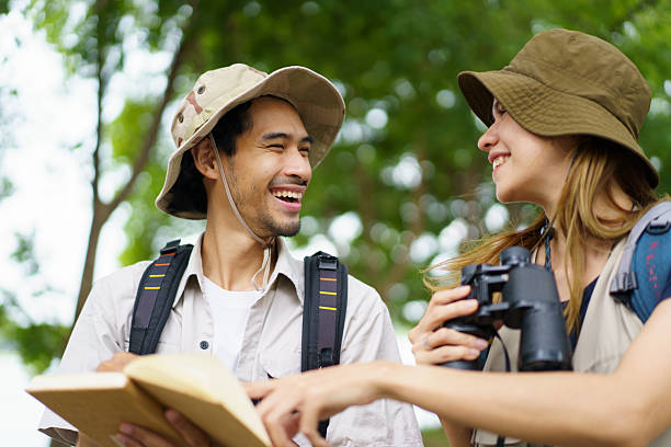 istock Man and woman joyfully birdwatching activity in a park. They study about bird watching. 2227505775